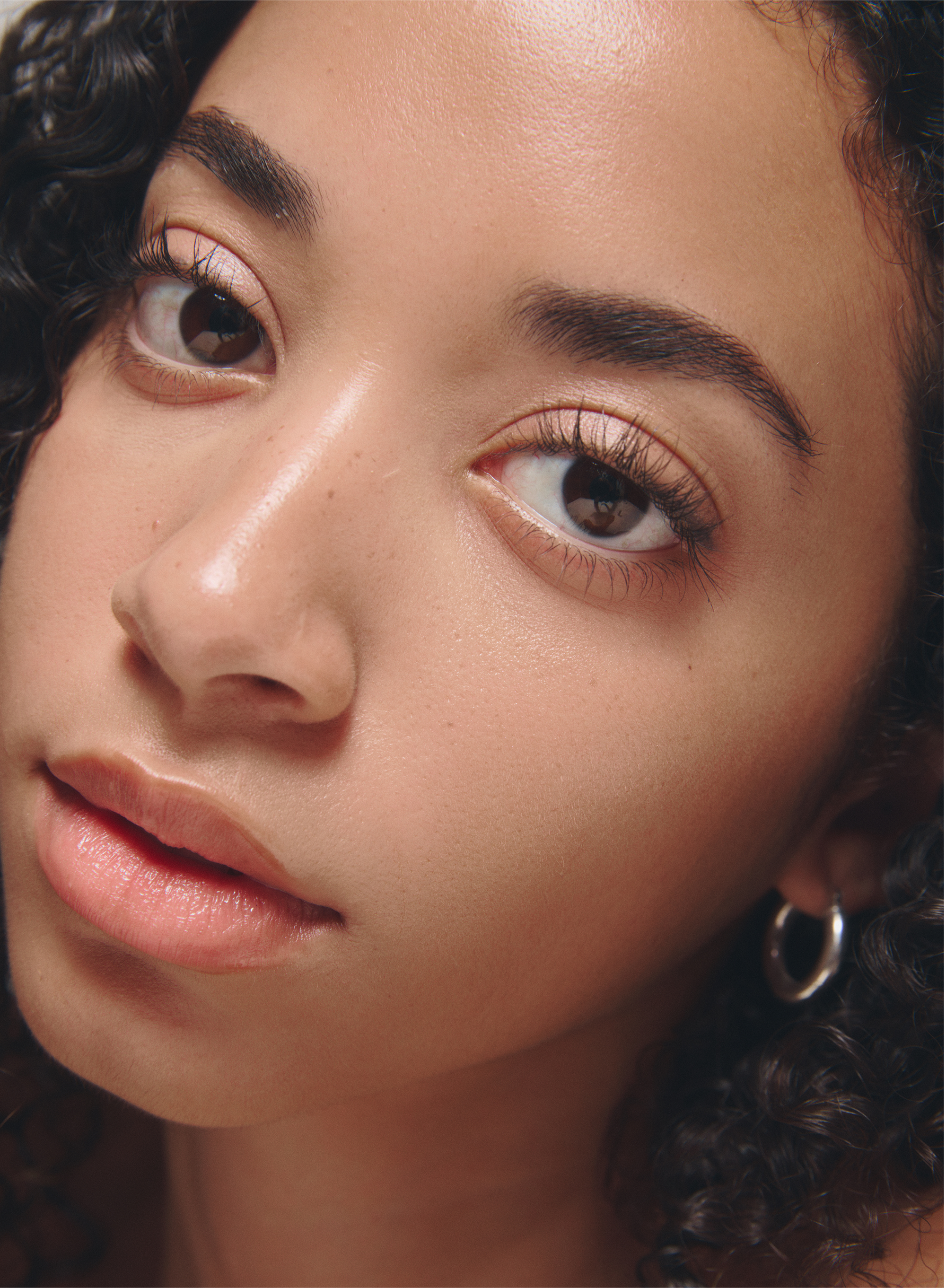 Close-up of a person with curly hair and clear skin